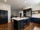 Open kitchen with island seating, wine fridge, stainless appliances, and eat-in dining at 300 W Roanoke Park Dr, Raleigh, NC 27608
