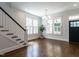 Bright living room featuring hardwood floors, modern lighting, and staircase at 300 W Roanoke Park Dr, Raleigh, NC 27608