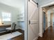 A home office space featuring open shelving, desk and chair next to a barn door at 300 W Roanoke Park Dr, Raleigh, NC 27608