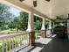 Spacious front porch with brick pillars, railings, and ceiling fans for comfortable outdoor living at 300 W Roanoke Park Dr, Raleigh, NC 27608
