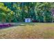 Sprawling backyard featuring a storage shed and mature trees at 303 Winhaven St, Roxboro, NC 27573