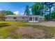 Backyard featuring a home with white siding, a screened in porch, and a well-manicured lawn at 303 Winhaven St, Roxboro, NC 27573