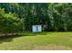 Well manicured backyard featuring a storage shed and mature trees at 303 Winhaven St, Roxboro, NC 27573