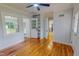 Bedroom featuring hardwood floors, neutral paint, a ceiling fan, and access to the sunroom and kitchen at 303 Winhaven St, Roxboro, NC 27573