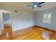 Spacious bedroom featuring hardwood floors, a ceiling fan, and natural light from a window at 303 Winhaven St, Roxboro, NC 27573