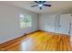 Well-lit bedroom featuring hardwood floors, a ceiling fan, closet, and window overlooking the yard at 303 Winhaven St, Roxboro, NC 27573