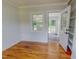 Bedroom featuring hardwood floors, neutral paint, a ceiling fan, and access to the sunroom at 303 Winhaven St, Roxboro, NC 27573