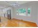 Bright dining area featuring hardwood floors, modern lighting, and a large window overlooking the backyard at 303 Winhaven St, Roxboro, NC 27573