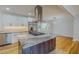Modern kitchen island with marble countertop, stainless steel appliances, and an elegant range hood at 303 Winhaven St, Roxboro, NC 27573