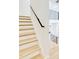 Bright staircase featuring light wood treads, white risers, and a sleek black handrail offers a modern touch at 322 S Dixon Ave # R, Cary, NC 27511