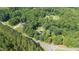 Aerial view showcasing a neighborhood with mature trees, homes, and community pool at 3315 Swepsonville Saxapahaw Rd, Graham, NC 27253