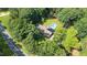 Aerial view of a home with an in-ground pool nestled among mature trees, providing a private and serene backyard setting at 3315 Swepsonville Saxapahaw Rd, Graham, NC 27253