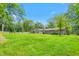 Expansive backyard featuring lush green lawn, mature trees, and a refreshing swimming pool at 3315 Swepsonville Saxapahaw Rd, Graham, NC 27253