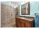 Bathroom featuring granite counters, wooden cabinets, tiled shower with bronze fixtures at 3315 Swepsonville Saxapahaw Rd, Graham, NC 27253