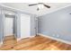 Light-filled bedroom with hardwood floors, ceiling fan, and adjacent closet and doorway at 3315 Swepsonville Saxapahaw Rd, Graham, NC 27253