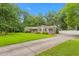 Well-manicured front yard with a long driveway leading to a home featuring mature trees and a welcoming facade at 3315 Swepsonville Saxapahaw Rd, Graham, NC 27253
