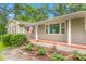 Charming home featuring a brick facade, a cozy front porch, and a manicured lawn with mature trees at 3315 Swepsonville Saxapahaw Rd, Graham, NC 27253