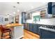 Open kitchen with island, stylish blue cabinets, and stainless steel appliances, perfect for cooking and entertaining at 3315 Swepsonville Saxapahaw Rd, Graham, NC 27253