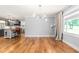Open-concept living room with hardwood floors connecting to a modern kitchen with gray cabinets at 3315 Swepsonville Saxapahaw Rd, Graham, NC 27253