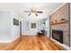Inviting living room with hardwood floors and a cozy fireplace featuring a brick surround and modern finishes at 3315 Swepsonville Saxapahaw Rd, Graham, NC 27253