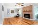 Cozy living room with a brick fireplace, hardwood floors, and comfortable seating area at 3315 Swepsonville Saxapahaw Rd, Graham, NC 27253