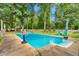 Inviting backyard pool surrounded by lush greenery and lounge seating at 3315 Swepsonville Saxapahaw Rd, Graham, NC 27253