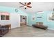 A bright sunroom features cool-colored walls, a ceiling fan, and access to the living room at 3315 Swepsonville Saxapahaw Rd, Graham, NC 27253