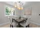 Cozy dining room featuring a modern chandelier, a square table, and a window view at 505 Drolmond Dr, Raleigh, NC 27615