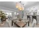 Open-concept dining room with modern chandelier flowing into a living room and kitchen at 505 Drolmond Dr, Raleigh, NC 27615