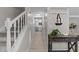 Bright entryway featuring hardwood floors, stairs, a hall table and a view of the kitchen at 505 Drolmond Dr, Raleigh, NC 27615