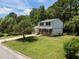 Charming two-story home with a brick facade, a blue door, a well manicured lawn, and mature trees at 505 Drolmond Dr, Raleigh, NC 27615