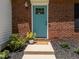 Close-up of the brick facade, blue door, and manicured landscaping at 505 Drolmond Dr, Raleigh, NC 27615