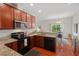 Bright kitchen features granite countertops, stainless steel appliances, and opens to the dining area with a sliding glass door at 507 Turmeric Ln, Durham, NC 27713