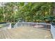 Back deck with white rails, plants, and lots of shade and trees at 5216 Woods End Rd, Hillsborough, NC 27278