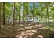 View of the home's backyard featuring mature trees and a wooden deck, providing a private and peaceful outdoor space at 5216 Woods End Rd, Hillsborough, NC 27278