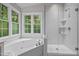 Bathroom featuring a walk-in shower, soaking tub, and natural light for a luxurious experience at 5216 Woods End Rd, Hillsborough, NC 27278