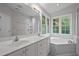 Bright bathroom featuring double sinks, a soaking tub, and natural light; great for relaxing at 5216 Woods End Rd, Hillsborough, NC 27278