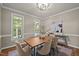 Bright dining room with natural light, a wooden table, and a view of the outdoor greenery through two windows at 5216 Woods End Rd, Hillsborough, NC 27278