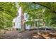 Two-story home featuring a brick chimney and a wooden deck, surrounded by mature trees and foliage at 5216 Woods End Rd, Hillsborough, NC 27278