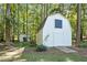 Exterior view of a charming white outbuilding and shed on the property, nestled among trees at 5216 Woods End Rd, Hillsborough, NC 27278