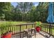 Enjoy outdoor dining on the wooden back deck, complete with bar-height table, seating and views of treed yard at 55 Kristopher Woods Dr, Youngsville, NC 27596