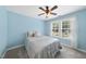 Inviting bedroom with soft blue walls, ceiling fan, and two large windows for natural light at 55 Kristopher Woods Dr, Youngsville, NC 27596