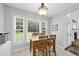 A brightly lit breakfast nook with natural light, a wooden table, and views of the back yard at 55 Kristopher Woods Dr, Youngsville, NC 27596