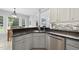 This kitchen features a stainless steel dishwasher, stone countertops, and grey cabinets at 55 Kristopher Woods Dr, Youngsville, NC 27596