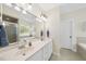 The main bathroom offers a large mirror, white cabinets, and a soaking tub at 55 Kristopher Woods Dr, Youngsville, NC 27596