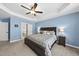 An airy main bedroom shows neutral walls, a ceiling fan, bedside lamps, and a dark wood bed frame at 55 Kristopher Woods Dr, Youngsville, NC 27596