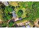 Aerial view of the home with lush greenery, outbuildings, ample parking, and a serene, private setting at 6022 Little Creek Church Rd, Clayton, NC 27520