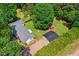 Aerial view of a home surrounded by mature trees, showcasing a large yard with outbuildings at 6022 Little Creek Church Rd, Clayton, NC 27520