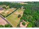 Aerial view of expansive property with fields, trees, and surrounding neighborhood at 6022 Little Creek Church Rd, Clayton, NC 27520