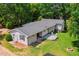 Aerial view of a backyard featuring a well-maintained lawn, a cozy deck, and a charming fire pit area at 6022 Little Creek Church Rd, Clayton, NC 27520